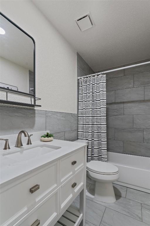 5902 Shreveport Dr, Austin, TX 78727 - full bathroom featuring vanity, tile walls, toilet, and shower / bath combo