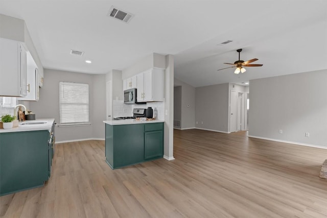5902 Shreveport Dr, Austin, TX 78727 - kitchen featuring green cabinetry, range, stainless steel microwave, baseboards, and recessed lighting