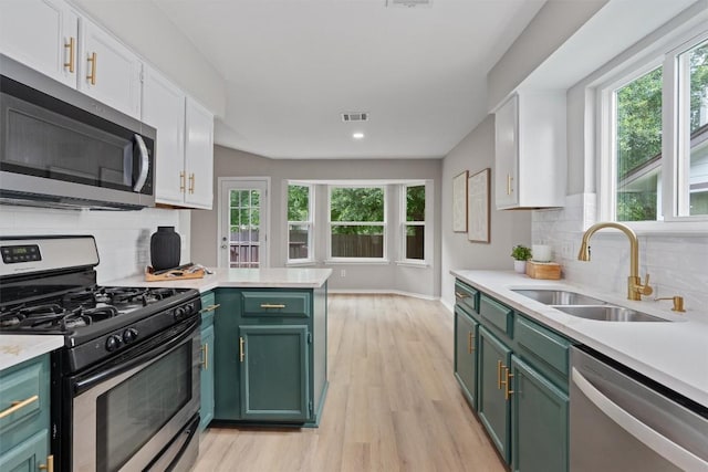5902 Shreveport Dr, Austin, TX 78727 - kitchen featuring stainless steel appliances, green cabinetry, a sink, light countertops, and recessed lighting