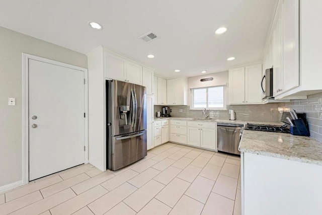 3310 Monument Dr, Round Rock, TX 78681 - kitchen featuring appliances with stainless steel finishes, tasteful backsplash, white cabinetry, light stone counters, and recessed lighting