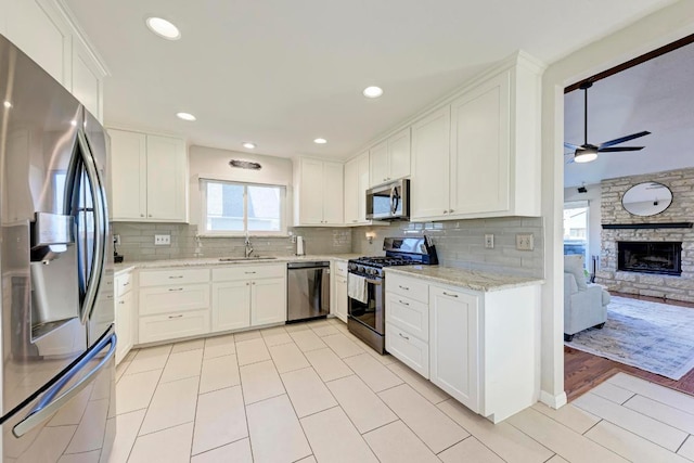 3310 Monument Dr, Round Rock, TX 78681 - kitchen featuring appliances with stainless steel finishes, a sink, ceiling fan, white cabinets, and backsplash