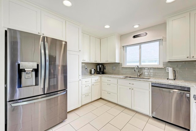3310 Monument Dr, Round Rock, TX 78681 - kitchen featuring appliances with stainless steel finishes, a sink, light tile patterned floors, decorative backsplash, and light stone counters