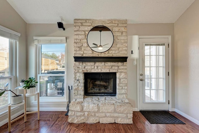 3310 Monument Dr, Round Rock, TX 78681 - unfurnished living room with a textured ceiling, wood finished floors, a fireplace, a ceiling fan, and baseboards