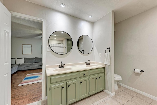3310 Monument Dr, Round Rock, TX 78681 - full bathroom with double vanity, a textured ceiling, toilet, tile patterned floors, and ceiling fan