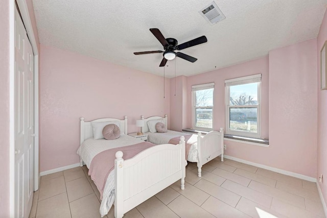 3310 Monument Dr, Round Rock, TX 78681 - bedroom featuring baseboards, a closet, a textured ceiling, light tile patterned flooring, and a ceiling fan