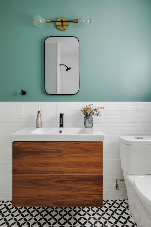 928 E 54th St, Austin, TX 78751 - bathroom featuring tile walls, vanity, and wainscoting