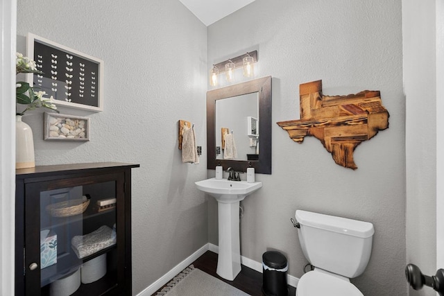 2003 Red Oak Cir, Round Rock, TX 78681 - half bathroom with toilet, a sink, baseboards, and wood finished floors