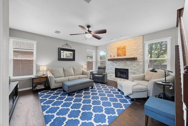 2003 Red Oak Cir, Round Rock, TX 78681 - living room featuring healthy amount of natural light, a stone fireplace, ceiling fan, and wood finished floors