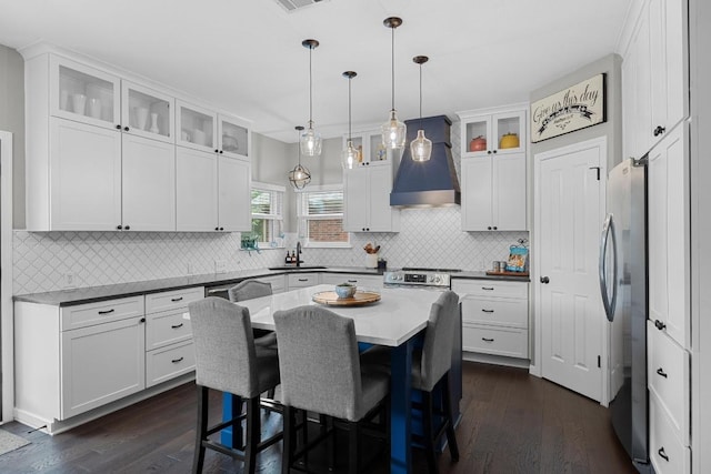2003 Red Oak Cir, Round Rock, TX 78681 - kitchen with wall chimney range hood, stainless steel appliances, dark wood-type flooring, white cabinetry, and a sink