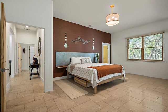 2819 Cross Rd, San Marcos, TX 78666 - bedroom featuring stone tile flooring, baseboards, and an accent wall