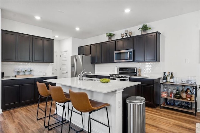 8103 Mandela Bnd, Austin, TX 78744 - kitchen featuring stainless steel appliances, a sink, a breakfast bar area, tasteful backsplash, and recessed lighting