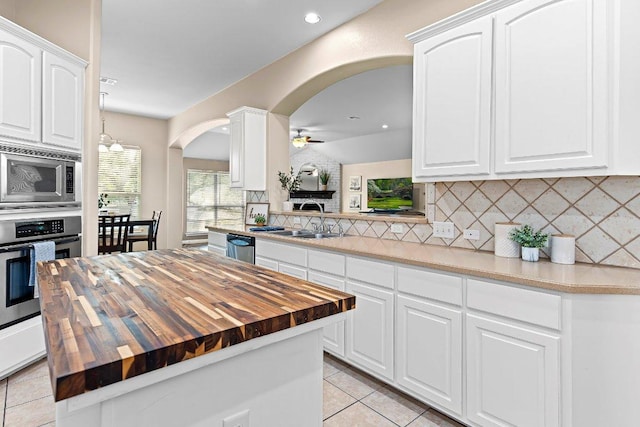 3712 Cerulean Way, Round Rock, TX 78681 - kitchen with wooden counters, appliances with stainless steel finishes, arched walkways, a ceiling fan, and backsplash