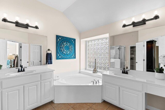 3712 Cerulean Way, Round Rock, TX 78681 - bathroom with lofted ceiling, a garden tub, two vanities, tile patterned floors, and a stall shower