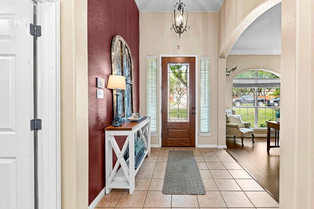 3712 Cerulean Way, Round Rock, TX 78681 - foyer entrance featuring arched walkways, ornamental molding, light tile patterned flooring, and a chandelier