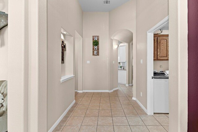 3712 Cerulean Way, Round Rock, TX 78681 - corridor featuring washer / clothes dryer, arched walkways, and light tile patterned flooring