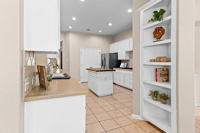 3712 Cerulean Way, Round Rock, TX 78681 - kitchen with open shelves, stainless steel refrigerator with ice dispenser, white cabinets, a kitchen island, and recessed lighting