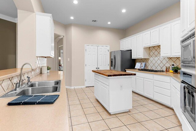 3712 Cerulean Way, Round Rock, TX 78681 - kitchen with appliances with stainless steel finishes, tasteful backsplash, white cabinets, recessed lighting, and a kitchen island