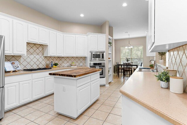 3712 Cerulean Way, Round Rock, TX 78681 - kitchen featuring appliances with stainless steel finishes, backsplash, light tile patterned floors, white cabinetry, and recessed lighting