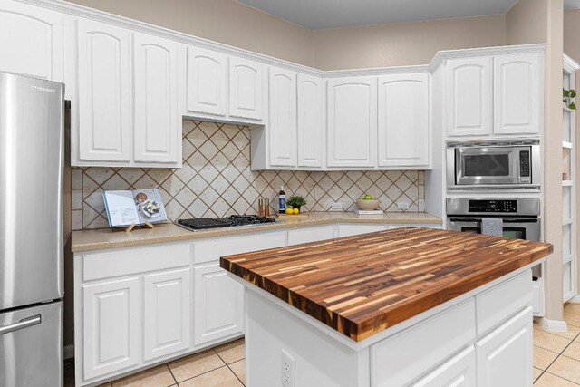 3712 Cerulean Way, Round Rock, TX 78681 - kitchen with appliances with stainless steel finishes, butcher block countertops, light tile patterned floors, and backsplash