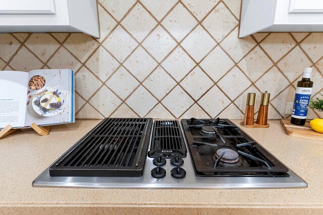 3712 Cerulean Way, Round Rock, TX 78681 - kitchen view of stovetop with downdraft, tasteful backsplash, white cabinets, and light countertops