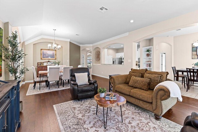 3712 Cerulean Way, Round Rock, TX 78681 - living area featuring arched walkways, a chandelier, dark wood finished floors, ornamental molding, and recessed lighting