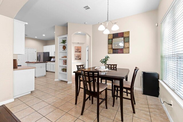 3712 Cerulean Way, Round Rock, TX 78681 - dining space featuring arched walkways, light tile patterned flooring, a chandelier, and recessed lighting