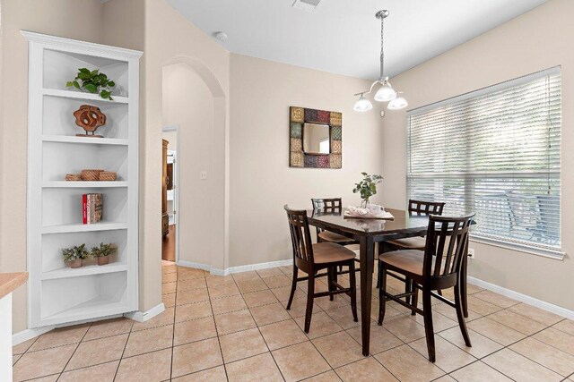 3712 Cerulean Way, Round Rock, TX 78681 - dining space featuring arched walkways, built in shelves, light tile patterned flooring, and a chandelier