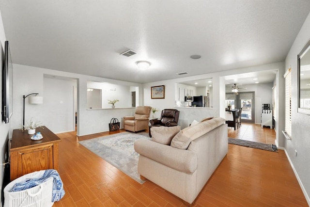 5504 Alomar Cv, Del Valle, TX 78617 - living area with ceiling fan, light wood-style flooring, and baseboards