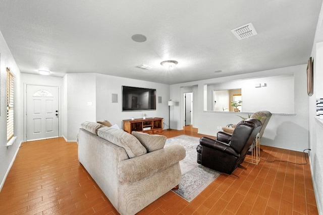 5504 Alomar Cv, Del Valle, TX 78617 - living room featuring wood finished floors, baseboards, and a textured ceiling