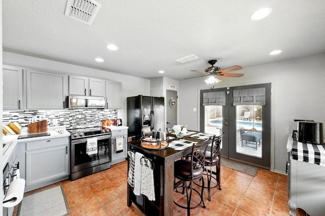 5504 Alomar Cv, Del Valle, TX 78617 - kitchen featuring stainless steel appliances, decorative backsplash, light countertops, a ceiling fan, and recessed lighting