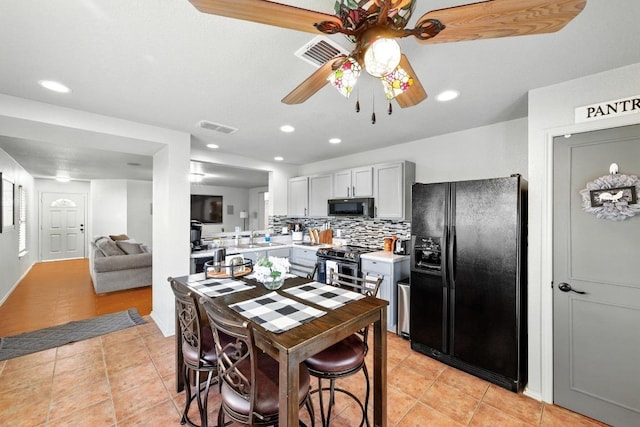 5504 Alomar Cv, Del Valle, TX 78617 - kitchen with black appliances, light countertops, a sink, decorative backsplash, and light tile patterned floors