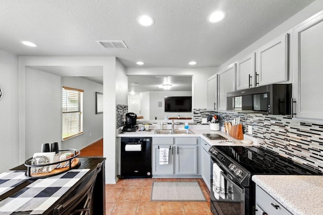 5504 Alomar Cv, Del Valle, TX 78617 - kitchen with black appliances, a sink, backsplash, light countertops, and recessed lighting