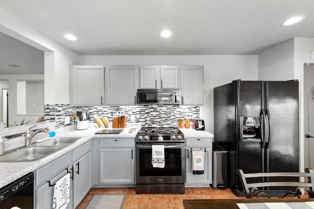 5504 Alomar Cv, Del Valle, TX 78617 - kitchen featuring black appliances, a sink, light countertops, decorative backsplash, and recessed lighting