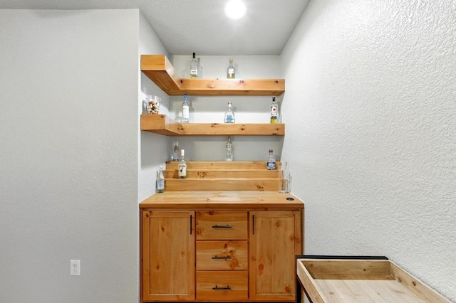 5504 Alomar Cv, Del Valle, TX 78617 - kitchen with wooden counters, open shelves, and a textured wall