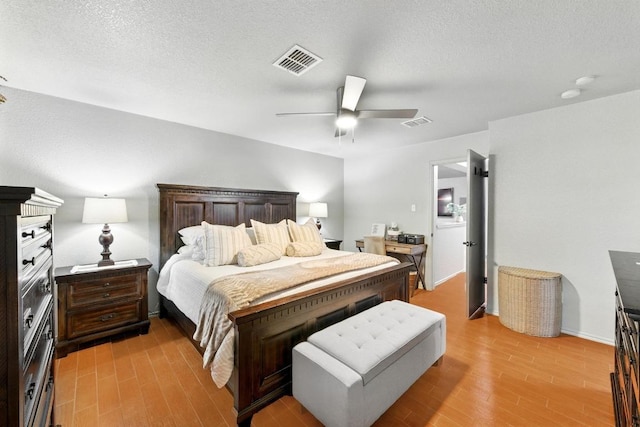 5504 Alomar Cv, Del Valle, TX 78617 - bedroom with light wood-type flooring, ceiling fan, and a textured ceiling