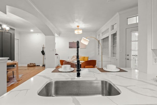 9525 N Capital Of Texas Hwy Unit 617, Austin, TX 78759 - kitchen featuring a sink, arched walkways, crown molding, decorative light fixtures, and light stone countertops