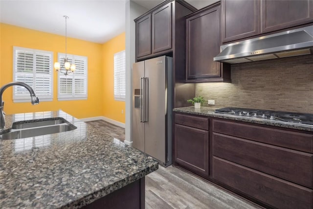 204 Hopping Peach St, San Marcos, TX 78666 - kitchen with appliances with stainless steel finishes, a sink, under cabinet range hood, and decorative backsplash