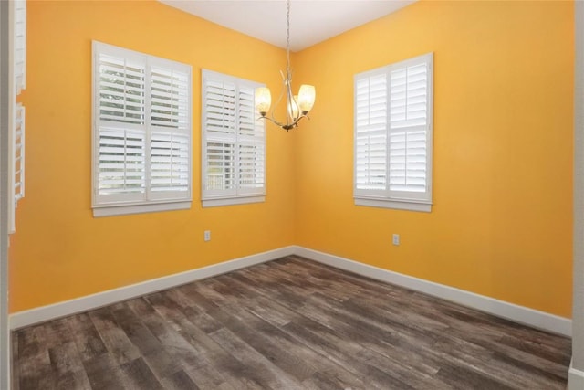 204 Hopping Peach St, San Marcos, TX 78666 - spare room with a chandelier, dark wood-style flooring, and baseboards