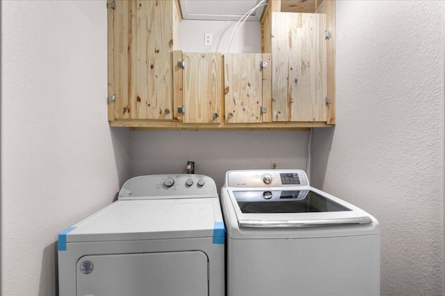 1015 E Yager Ln Unit 187, Austin, TX 78753 - washroom featuring washing machine and clothes dryer, cabinet space, and a textured wall