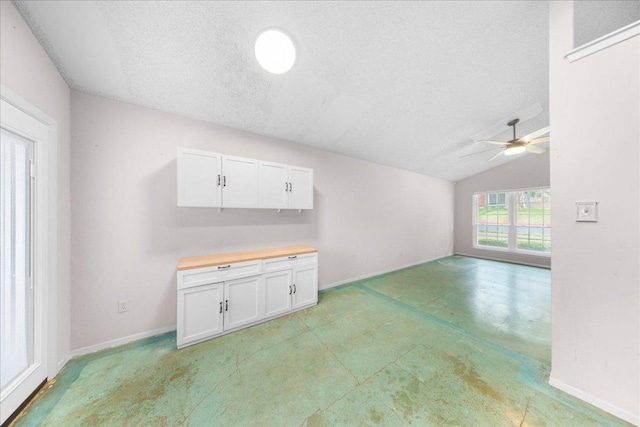 1015 E Yager Ln Unit 187, Austin, TX 78753 - unfurnished living room featuring ceiling fan, lofted ceiling, a textured ceiling, and baseboards