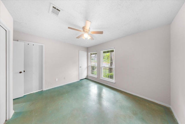 1015 E Yager Ln Unit 187, Austin, TX 78753 - unfurnished bedroom featuring baseboards, finished concrete floors, a textured ceiling, and ceiling fan
