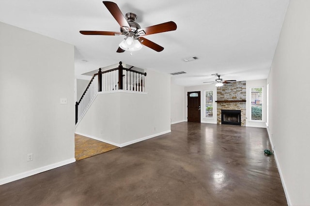 1115 Byers Ln, Austin, TX 78753 - unfurnished living room with ceiling fan, finished concrete flooring, stairs, and a stone fireplace