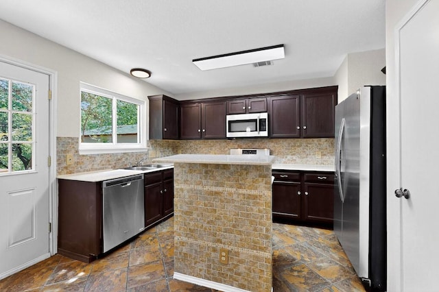 1115 Byers Ln, Austin, TX 78753 - kitchen with appliances with stainless steel finishes, dark brown cabinetry, light countertops, and backsplash