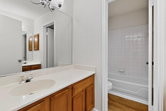 1115 Byers Ln, Austin, TX 78753 - bathroom featuring toilet, vanity, a chandelier, wood finished floors, and shower / bathtub combination