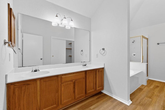 1115 Byers Ln, Austin, TX 78753 - bathroom with a stall shower, wood finished floors, double vanity, and a garden tub