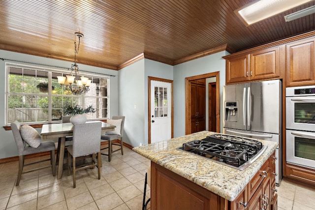 3 Hillview Dr, Round Rock, TX 78664 - kitchen with appliances with stainless steel finishes, a chandelier, a center island, light stone countertops, and brown cabinetry