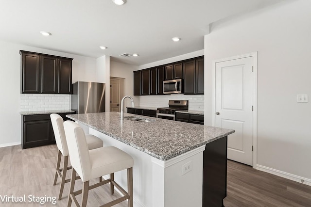 202 Delaware Mountains Ter, Dripping Springs, TX 78620 - kitchen with appliances with stainless steel finishes, baseboards, a sink, light wood-style flooring, and recessed lighting