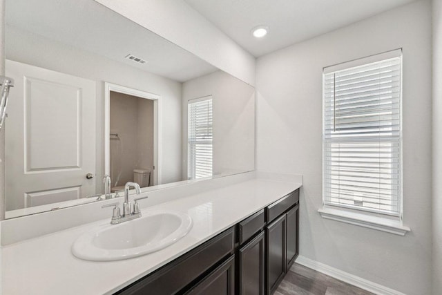202 Delaware Mountains Ter, Dripping Springs, TX 78620 - bathroom featuring vanity, toilet, baseboards, and wood finished floors