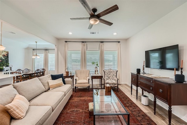 12904 Cerro Castellan Trce, Manor, TX 78653 - living room with dark wood-style flooring, a ceiling fan, recessed lighting, baseboards, and a chandelier