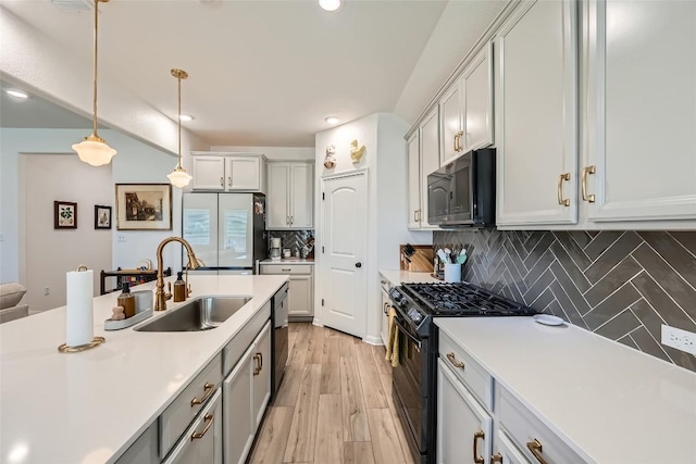 12904 Cerro Castellan Trce, Manor, TX 78653 - kitchen featuring black appliances, a sink, light countertops, recessed lighting, and pendant lighting